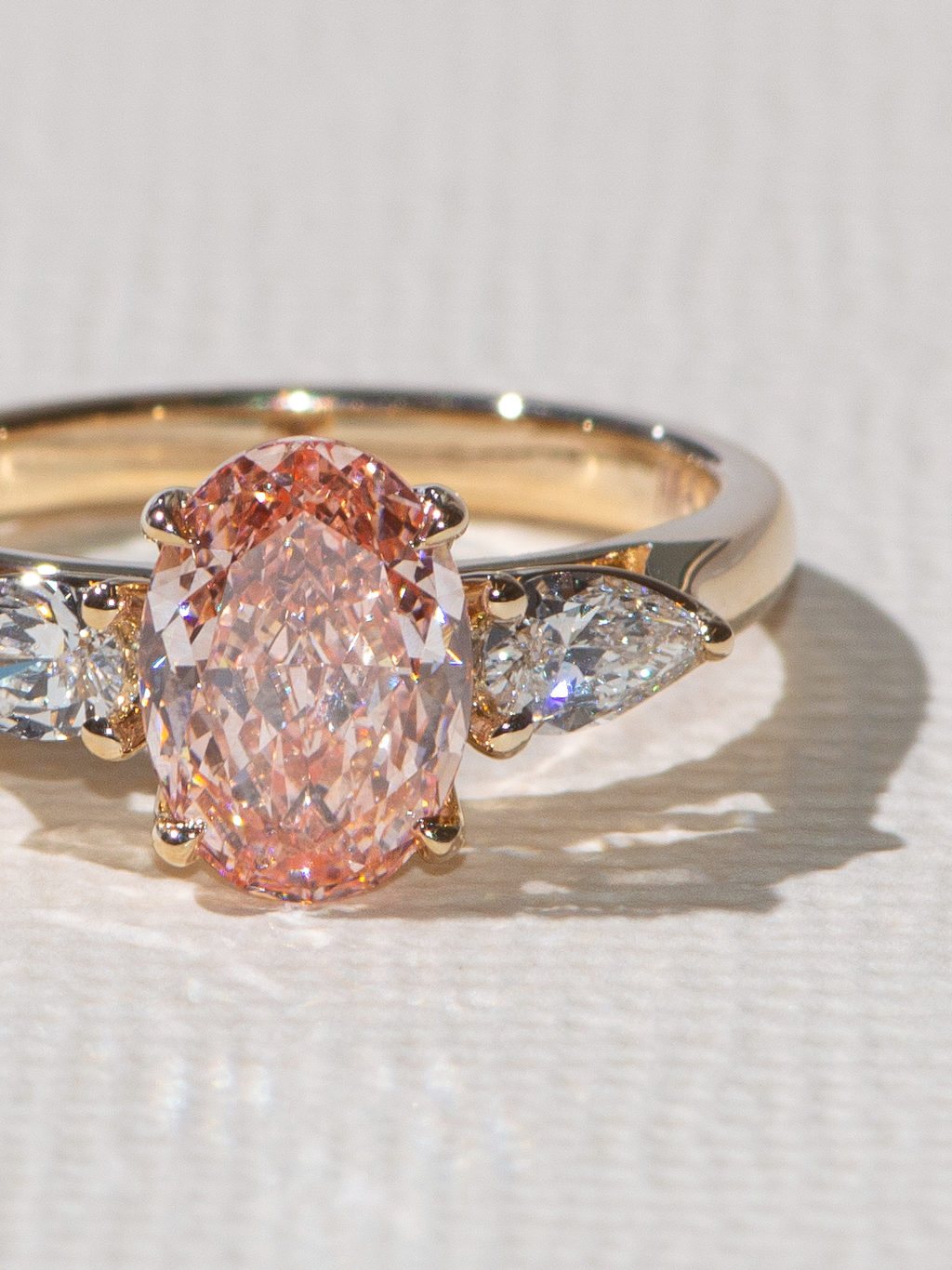 Our classic three stone oval and pears with a oval pink lab diamond center